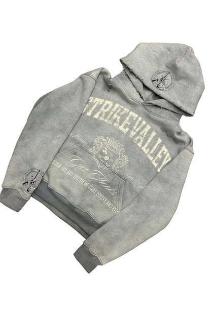 Gray hoodie with branding on a gray surface